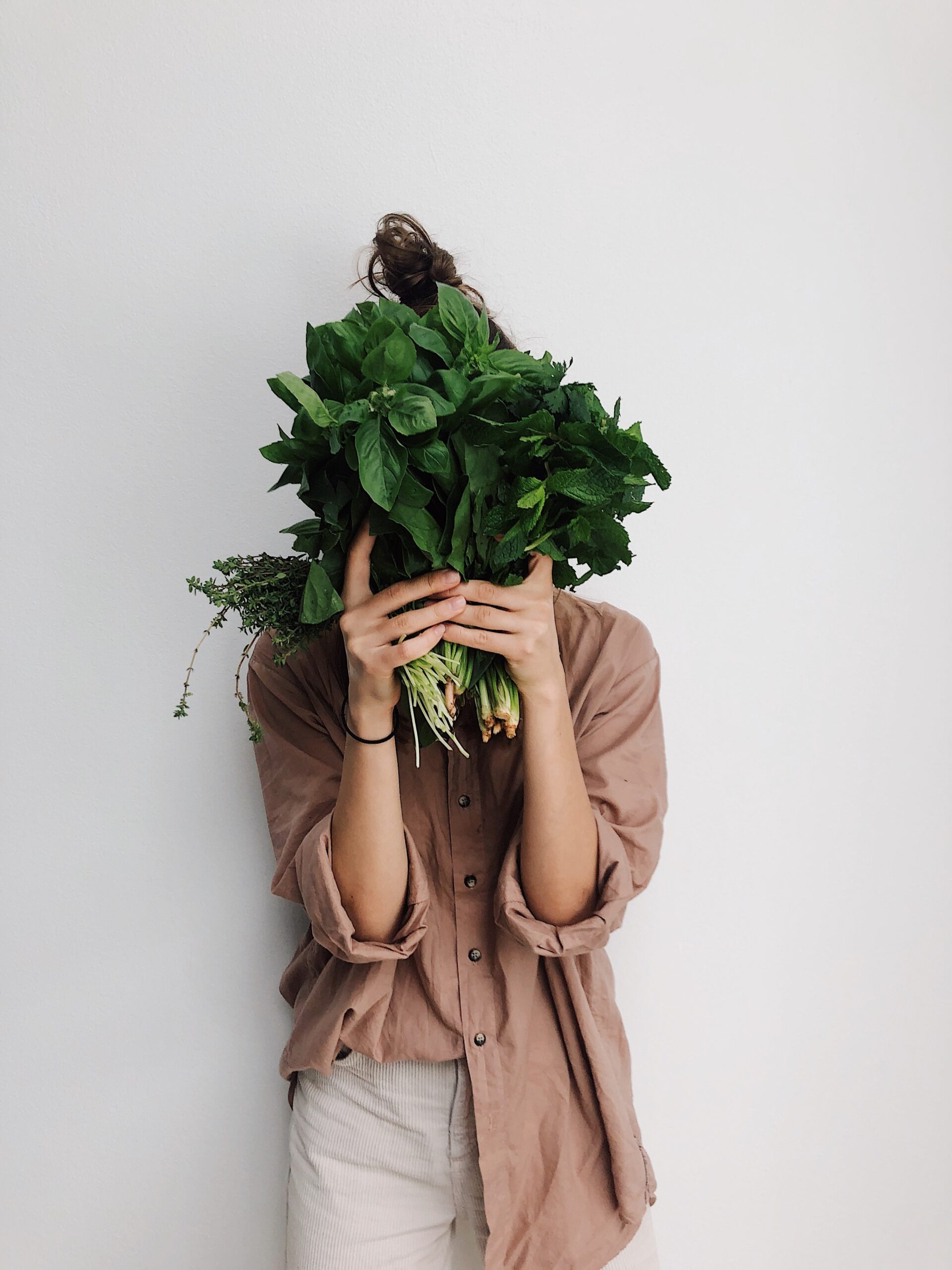 woman holding green leafy vegetables